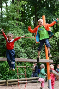 zwei Kinder springen von einem Balken