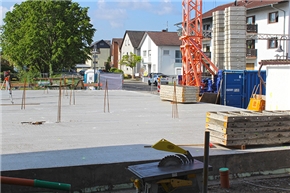 Bodenplatte aus Beton mit Baukran im Hintergrund