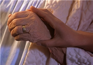 Bild: © Visionär - fololia.com Hand eines jungen Menschen umfängt Hand eines alten Menschen
