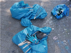 Halb volle, blaue Müllsäcke und Handschuhe einer Clean Up Aktion.