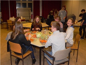 Firmlinge kochen für Obdachlose sechs Jugendliche sitzen am Tisch und schneiden Gemüse zum Kochen
