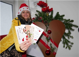 Auf den Bild werden drei Weihnachtskarten von einer Frau präsentiert.