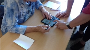Jugendlicher hilft Seniorin mit Smartphone