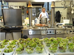 Küchenchef Hans Schauer steht hinter dem Ofen, vor ihm stehen viele Salatschüsselchen  / Foto: Schedlbauer