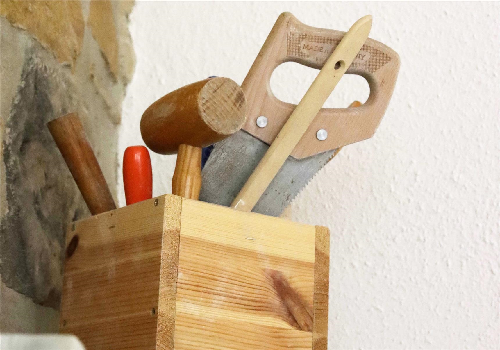Säge, Holzhammer, Pinsel in einer Holzkiste 