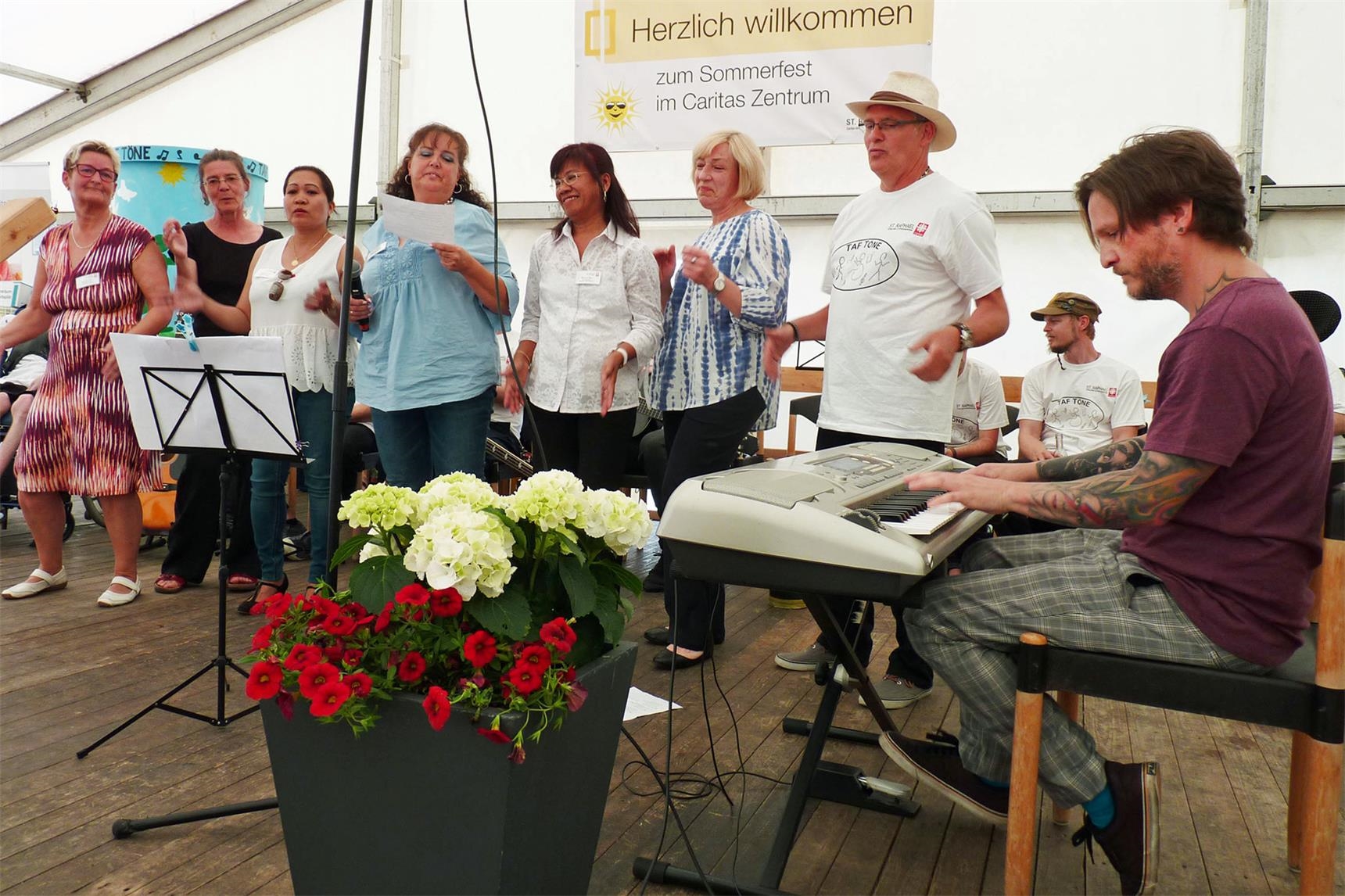 Heilerziehungspfleger Alex Justen (rechts) und weitere Mitarbeiter präsentieren den „Leitsätze-Song“. (Foto: Sonja Freer)