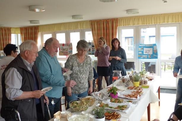 Mehrere Personen stehen mit Tellern an einem gesunden Buffet (Aktionswoche "Natürlich gut kochen" im St. Josef)