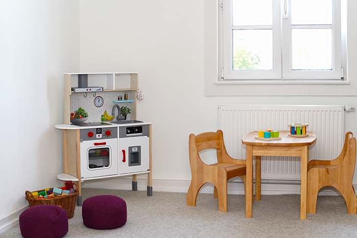 Kinderspielzimmer mit Spielküche,Tischchen und zwei Stühlen, Sitzkissen und Bauklötzen (Caritasverband Darmstadt e. V. / Jens Berger)