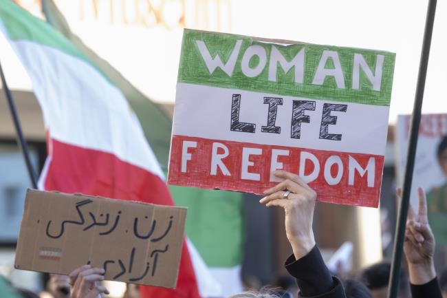 Iranische Flagge auf Karton gemalt mit Aufschrift Woman Life Freedom
