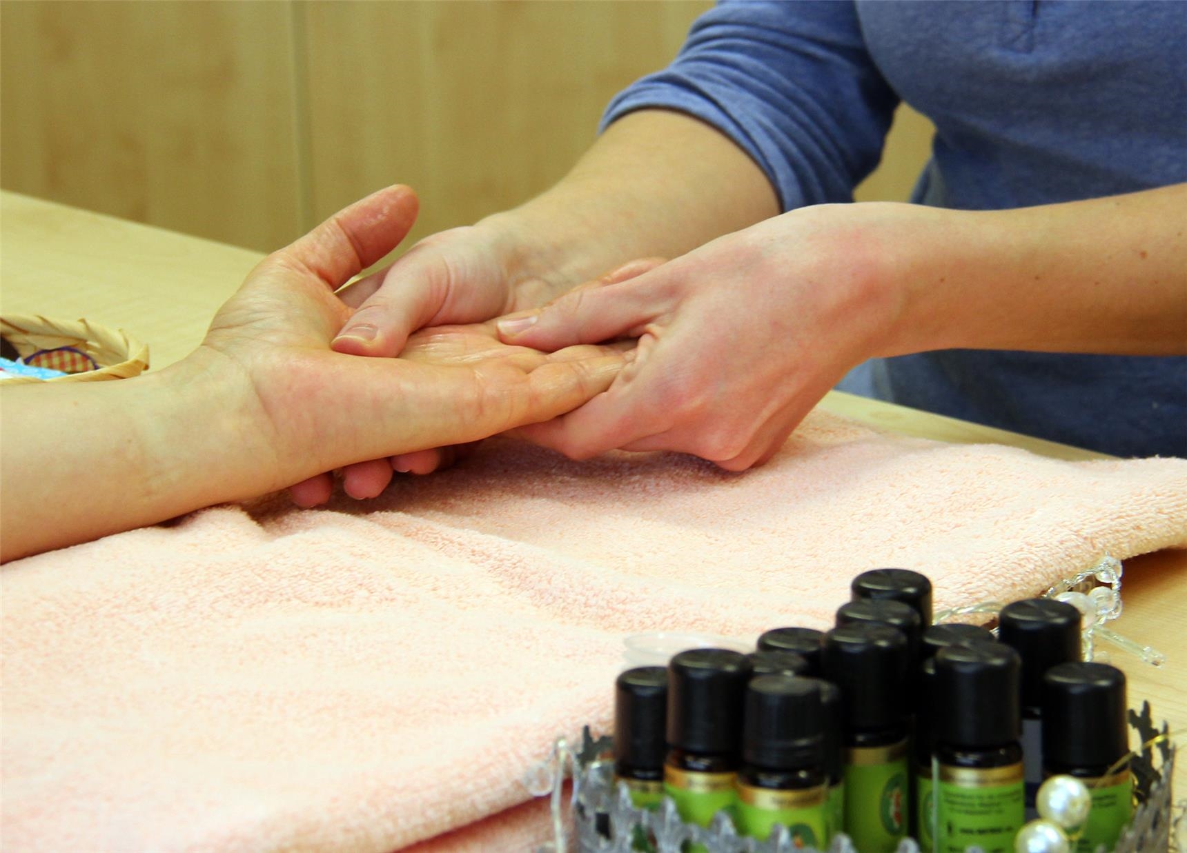 Aromapflege: Eine Hospiz-Mitarbeiterin gibt eine Handmassage mit Duftöl. 