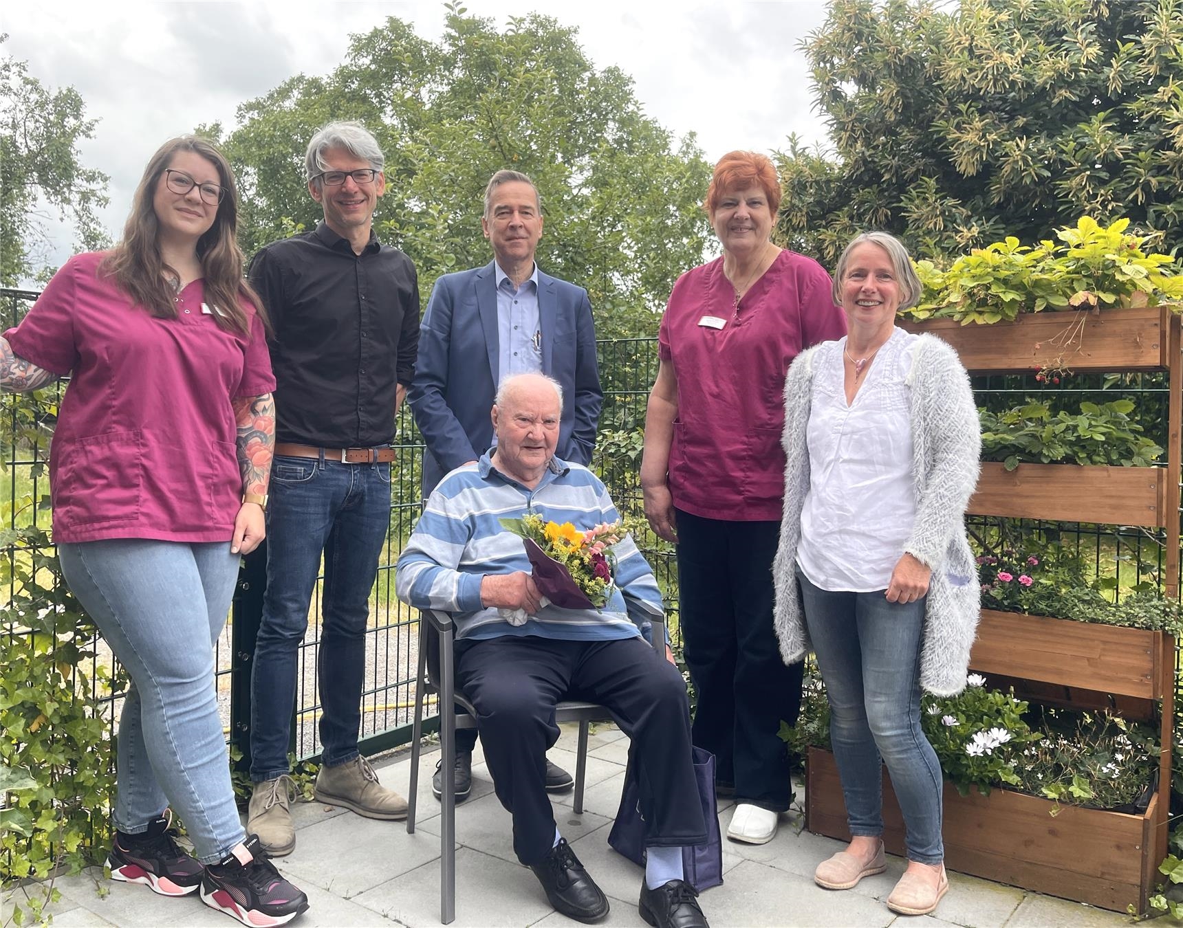 Kleine Menschengruppe rund um Bernhard Fockenberg, 89jähriger Tagesgast