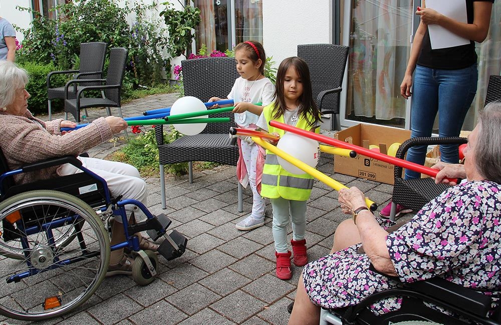 Zwei Mädchen mit zwei älteren Damen beim Spielen (Caritasverband Mannheim)