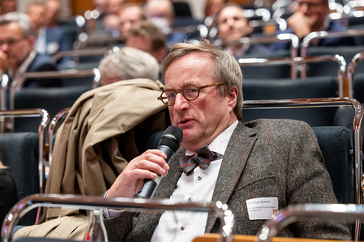 Ein Teilnehmer hält ein Mikrofon in der Hand und stellt eine Frage bei der Podiumsdiskussion beim 1. Kath. Krankenhaustag NRW am 10.11.2021 in Essen (Foto: Achim Pohl)