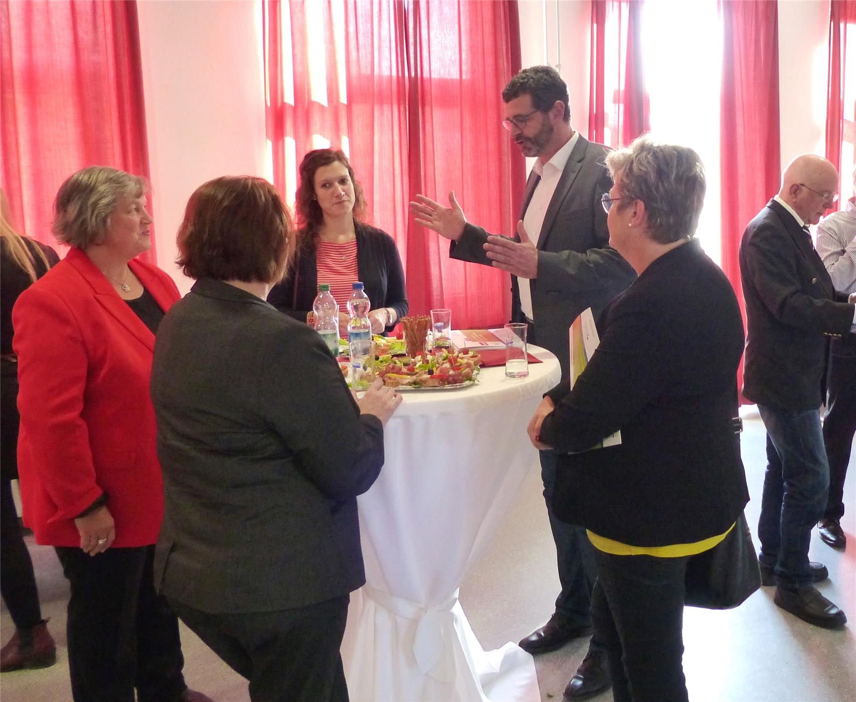Personen stehen um einen Tisch (Caritas Mosel-Eifel-Hunsrück e.V. )