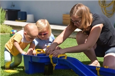 Mutter spielt mit Kindern im Garten / Deutscher Caritasverband / KNA / Harald Oppitz