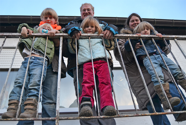 Familie Meßing lehnt an einem Geländer und wird aus der Froschperspektive fotografiert (Anna Woznicki)