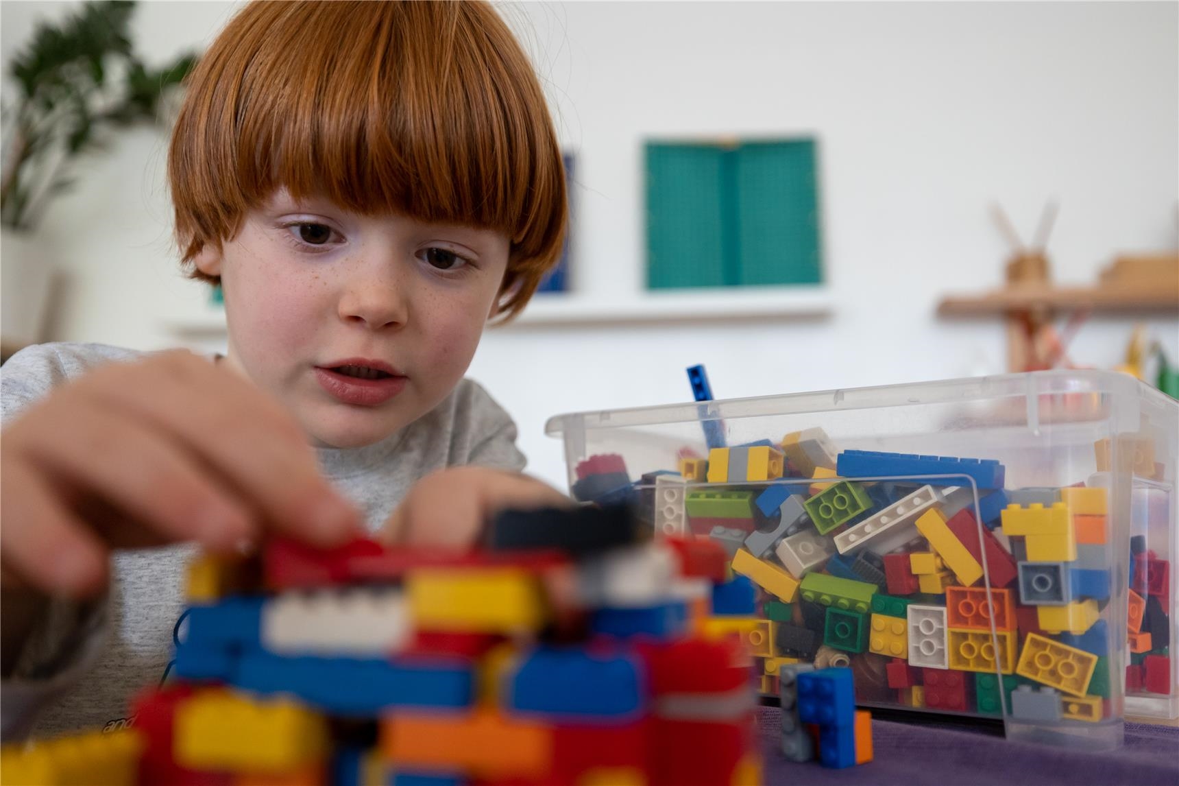 Ein Junge spielt mit Legosteinen. 
