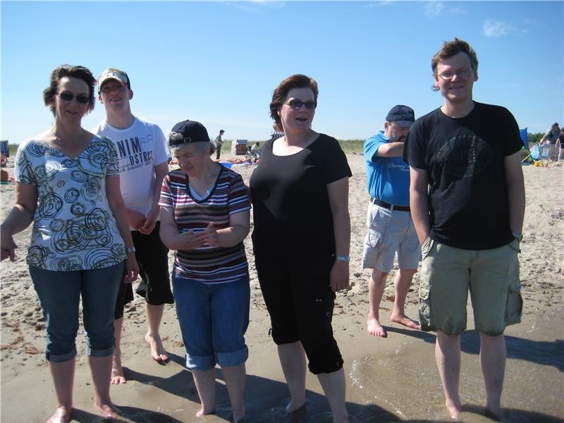 Gruppe Menschen steht am Strand, Hosenbeine aufgekrempelt (©caritasverband bocholt)