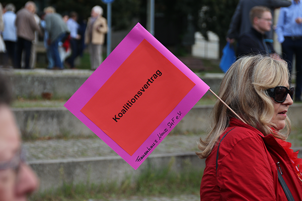 Eine Demonstrantin des Frauenhauses vom SkF e. V. Neuss, die ein Pappfähnchen mit der Aufschrift 'Koalitionsvertrag' trägt (Harald Westbeld)