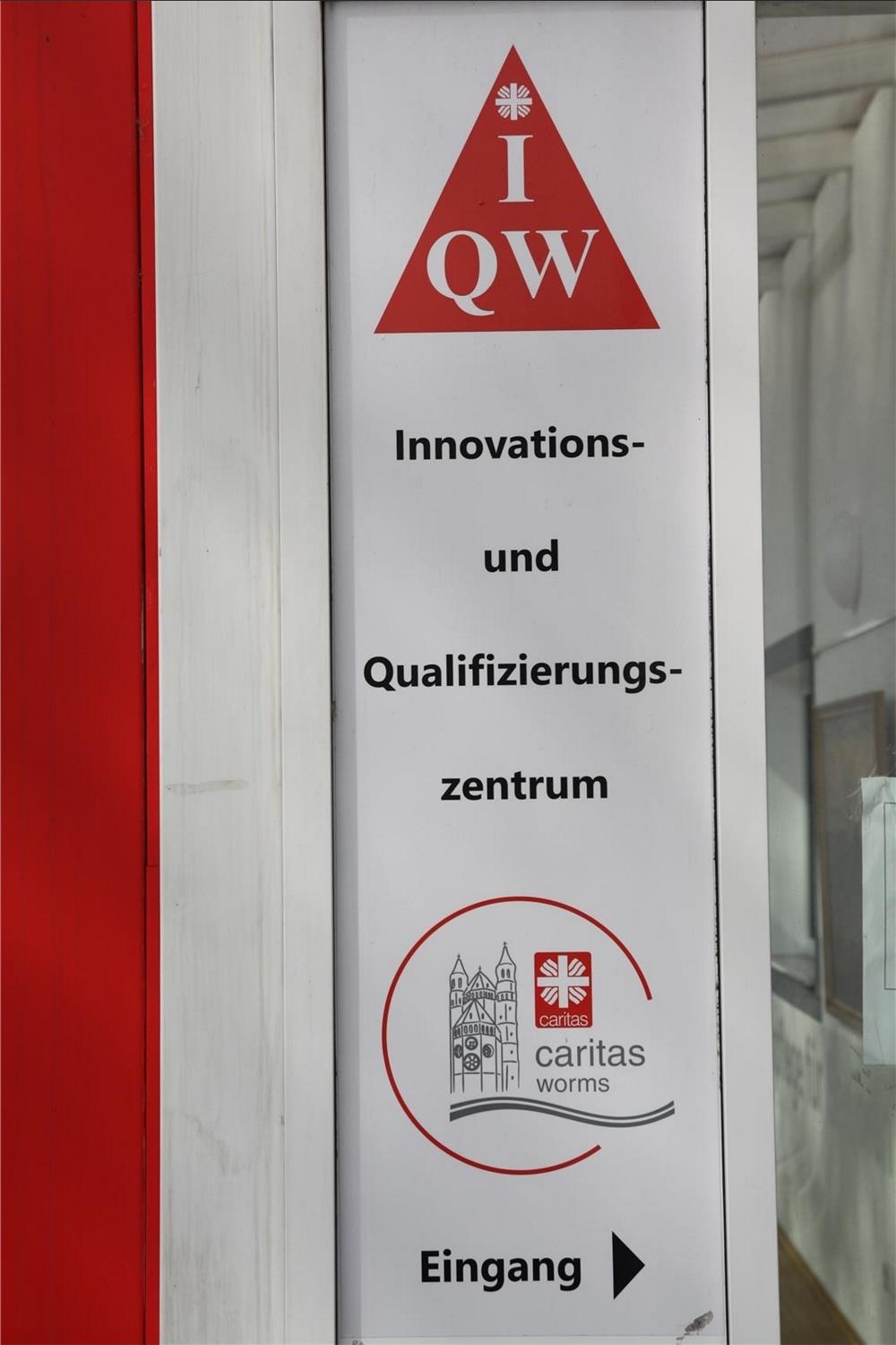 Schild am Eingang zum Innovations- und Qualifizierungszentrum Worms (IQW) (© Caritasverband Worms e. V.)