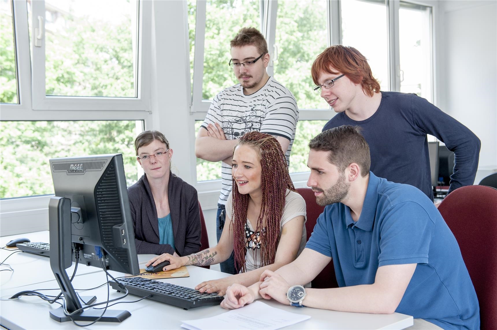 Gruppe junger Leute am Computer in der Jugendwerkstatt Büro und EDV der CJS Hannover (Ina Funk)