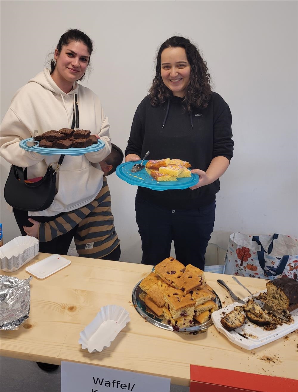 Zwei Mütter präsentieren ihren selbstgebackenen Kuchen für den Kuchenbasar 