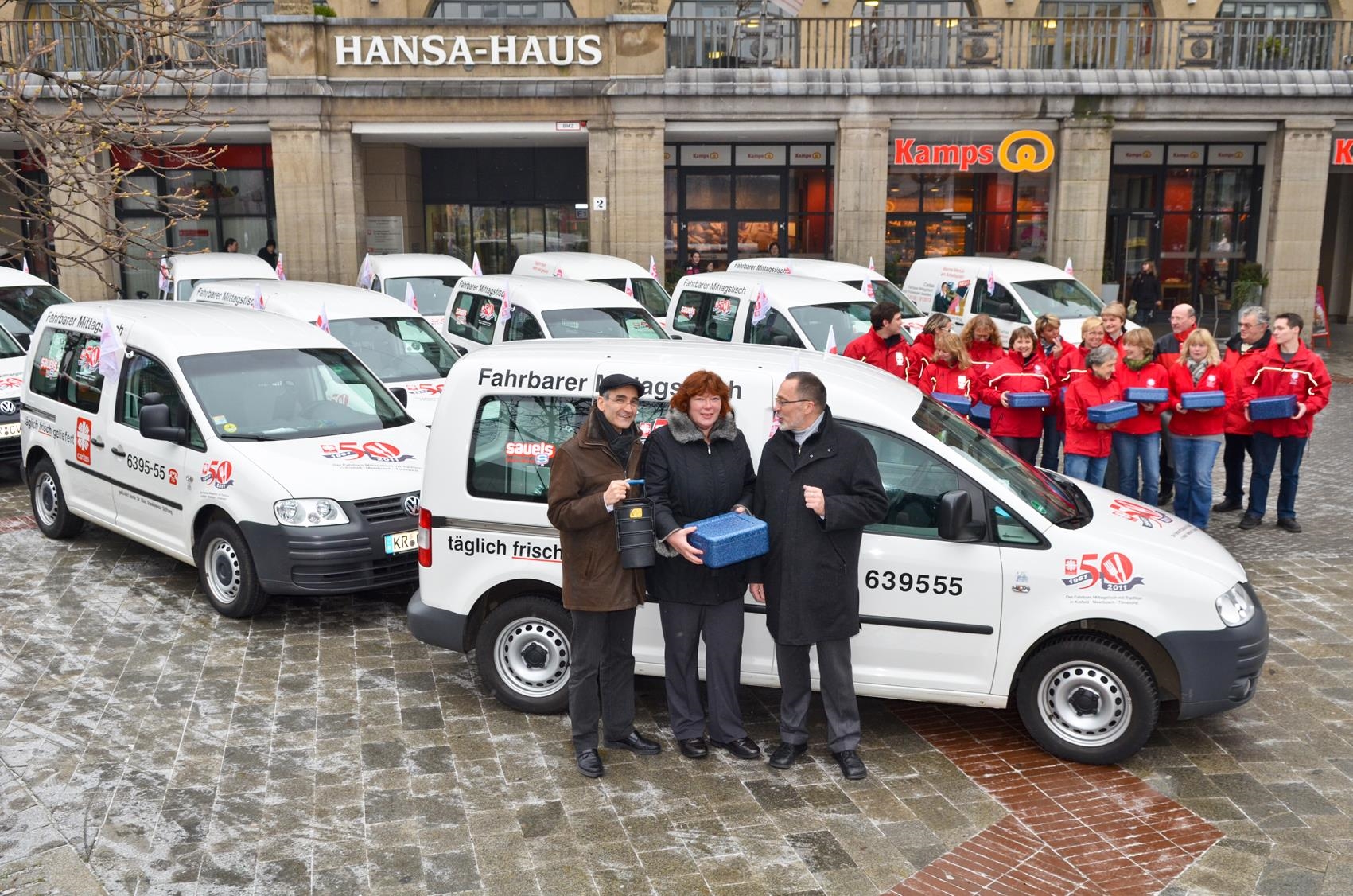 Caritas Mitarbeiter mit Autos vor dem Hansa Haus 