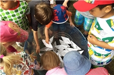 Kinder spielen mit Wasser und Papierbooten / Foto: Lisa Schulte