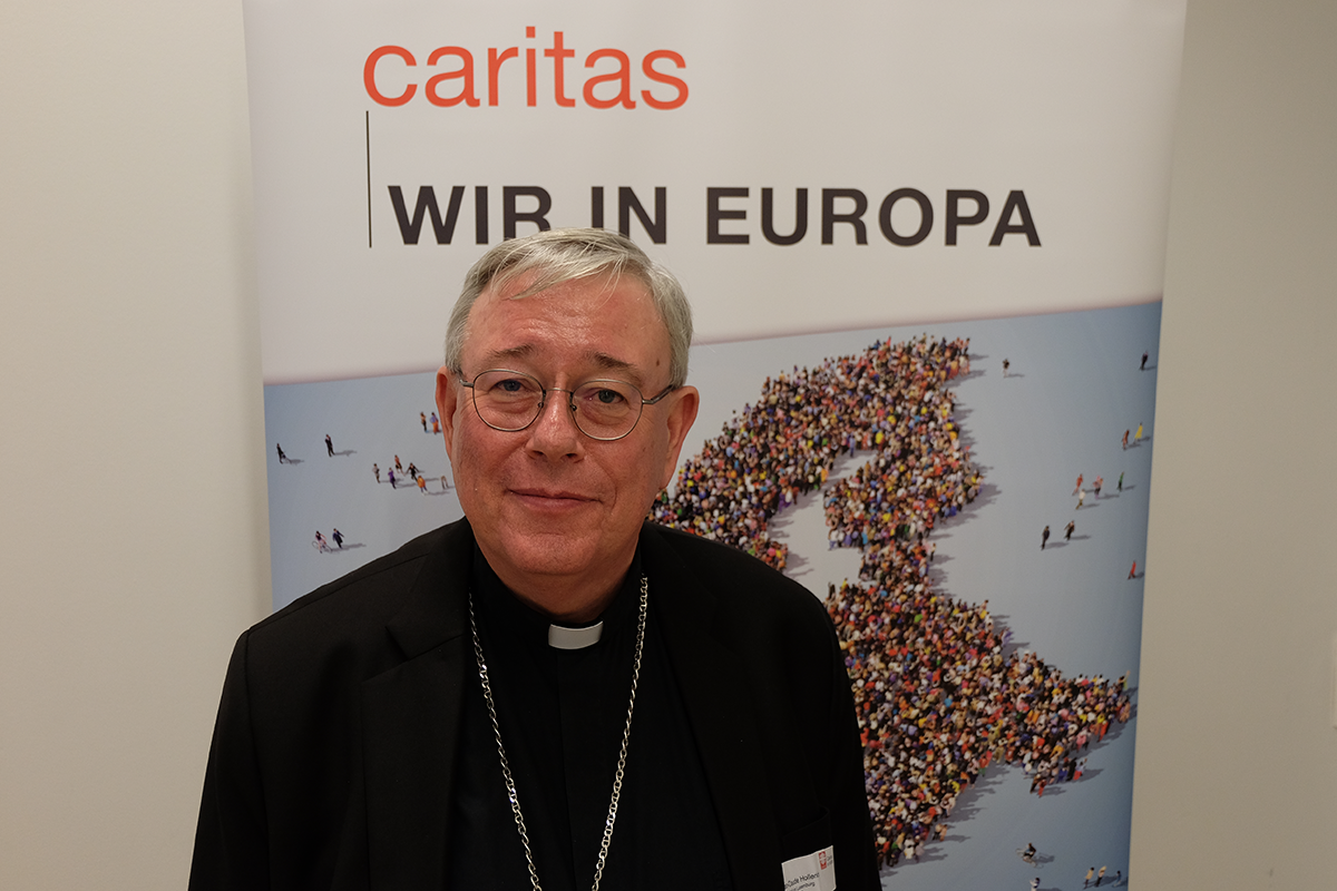 Porträt: Erzbischof Jean-Claude Hollerich, der auf dem CiNW-Europaforum vor einem Roll-up steht (Markus Lahrmann)