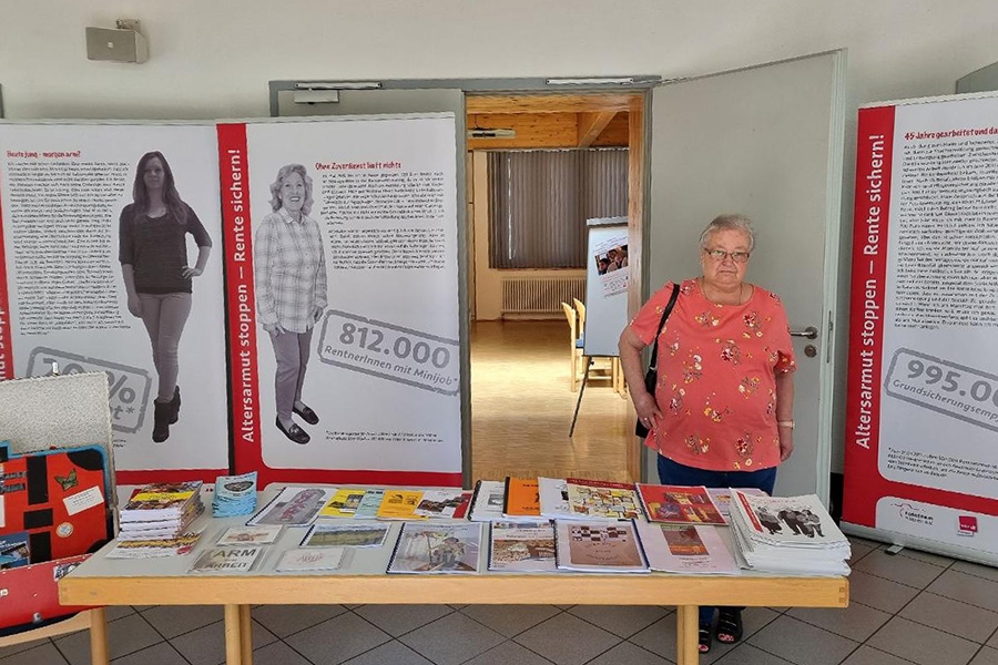 Frau hinter einem Informationstisch mit zahlreichen Flyern darauf (Willi Weiers, Erbach)