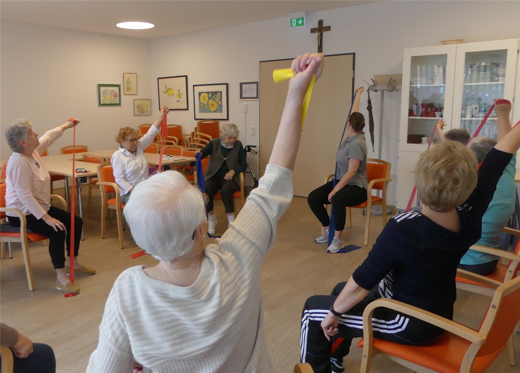Eine Gruppe Seniorinnen sitzt im Kreis und macht Fitnessübungen mit einem Gummiband (© CVO/Sabine Schilha )