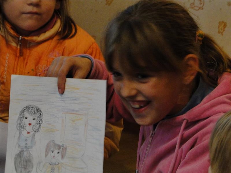 Katja zeigt ein Bild, das sie gemalt hat.
