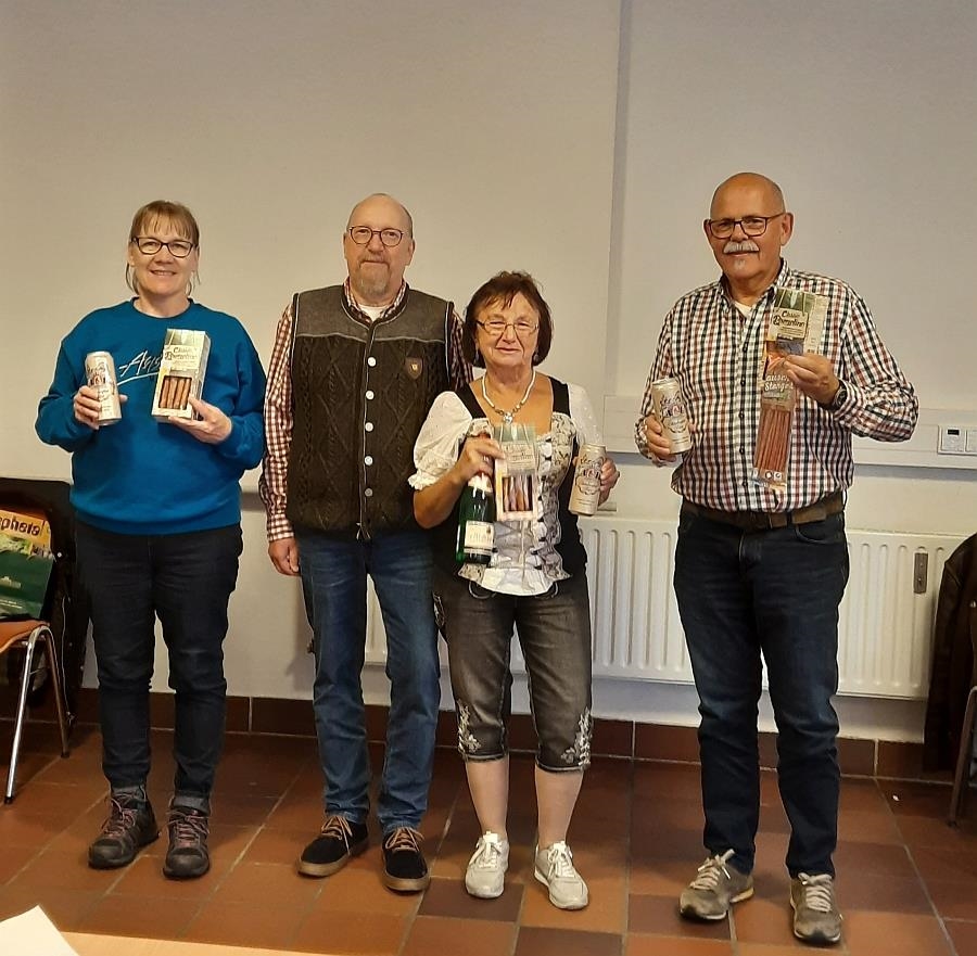 Die drei glücklichen Gewinner  halten ihre Gewinne und stehen mit Werner Althaus im Saal (Caritas Fulda)