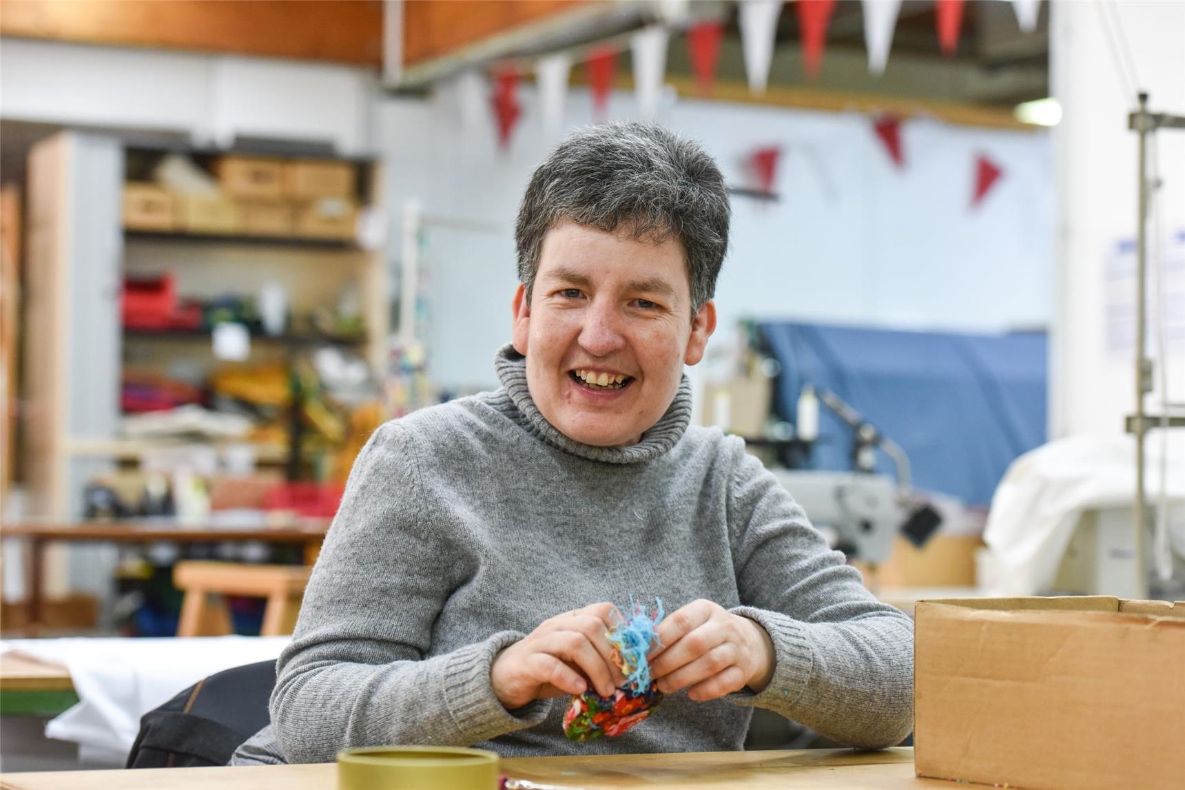 Frau mit  Behinderung arbeitet in Werkstatt für Menschen mit Behinderung.