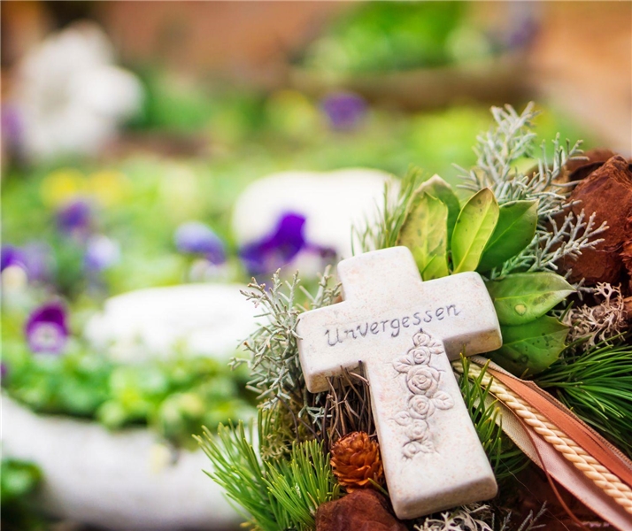 Grab mit Blumenschmuck und Kreuz