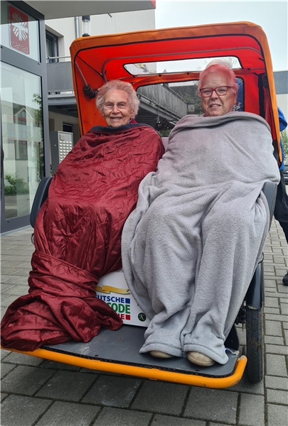 Zwei Personen in Decken gewickelt in einer Rikscha