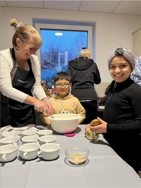 Eine Frau bereitet mit zwei Kindern ein Müsli zu.