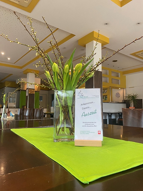 Cafe Auszeit - Tisch mit Blumenschmuck (Caritasverband Darmstadt e. V.)