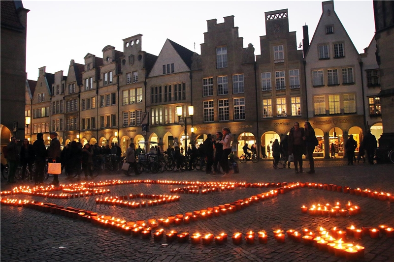 Tausende Kerzen leuchten in der Abenddämmerung.