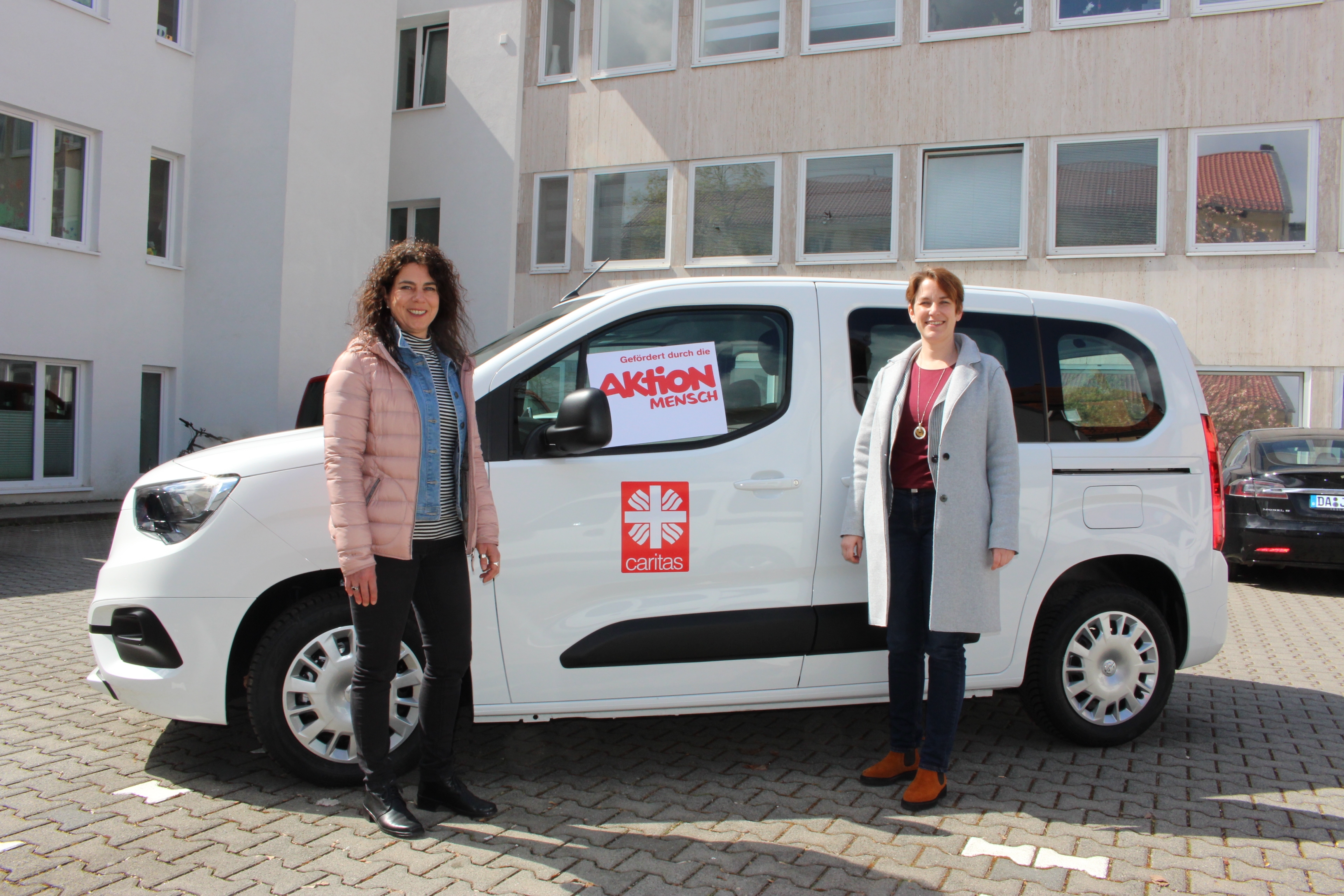 Zwei Frauen stehen vor einem Auto. (Caritasverband Darmstadt e. V.)