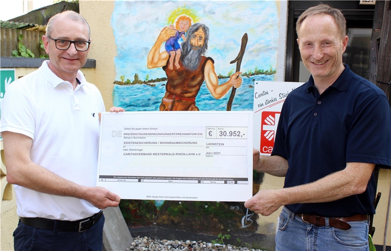 Walter Hartlich, Vorsitzender des Stiftungsbeirates der Caritas-Stiftung Westerwald-Rhein-Lahn, übergibt den symbolischen Scheck an Joachim Grämer von der Caritas.