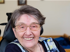Eine Seniorin sitzt im Rollstuhl und lächelt / Werner Krüper
