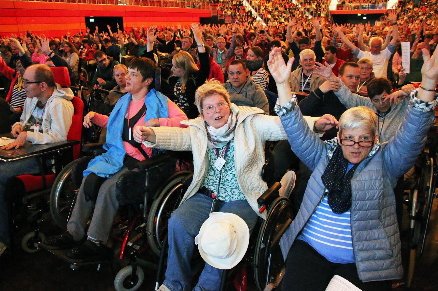 Das Foto zeigt eine große Menge begeisterter Menschen, im Vordergrund eine Reihe Rollstuhlfahrer. (Harald Westbeld)