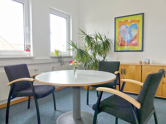 Runder Tisch mit drei Stühlen in einem Büroraum (Caritasverband Darmstadt e. V.)