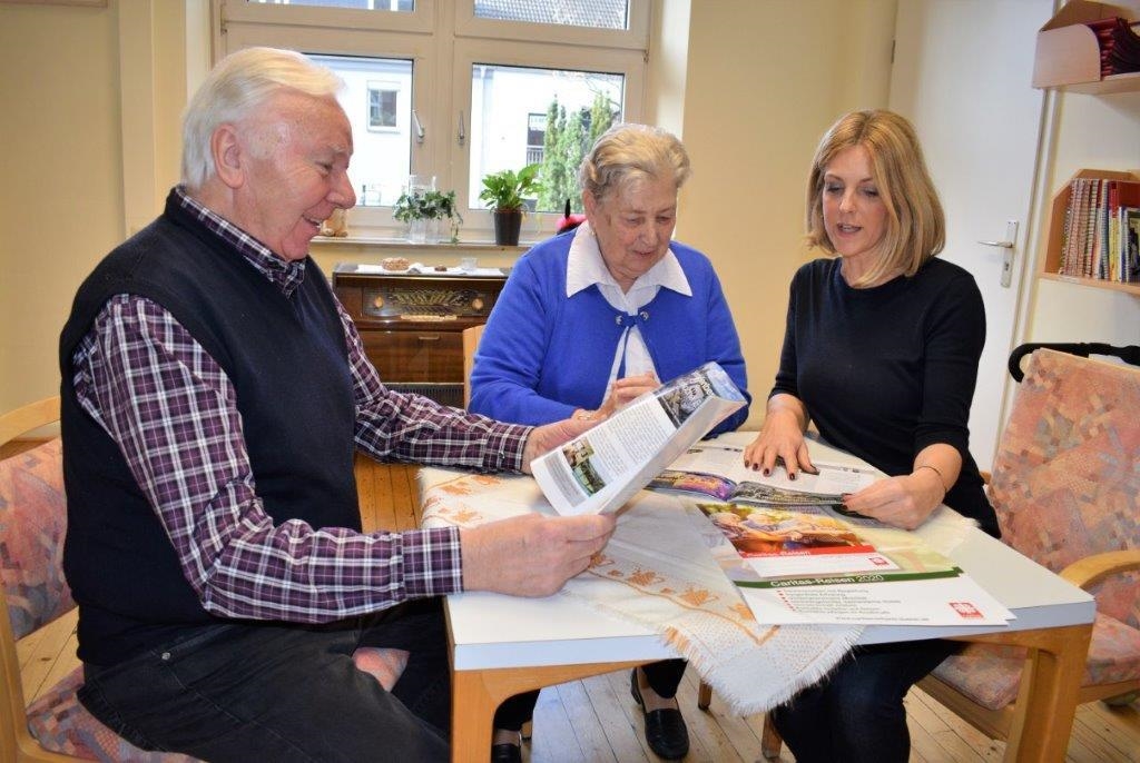 Frau zeigt einem älternen Ehepaar den Katalog (Erik Lehwald)