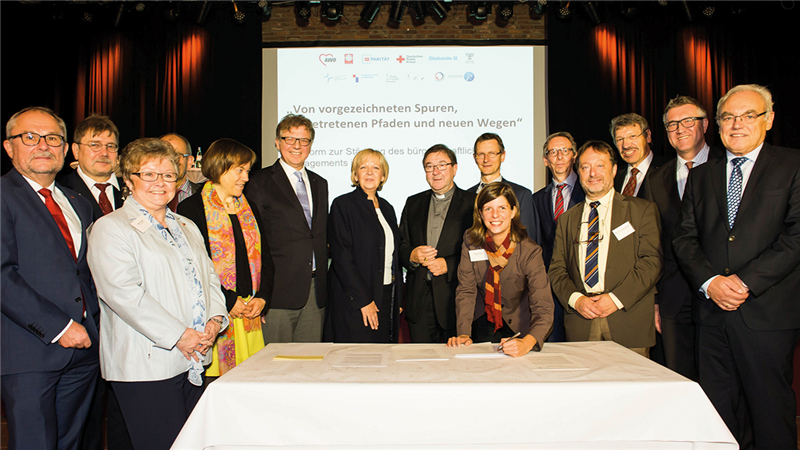Die Partner der Engagement-Plattform mit NRW-Ministerpräsidentin Hannelore Kraft, die bei der Gründungsveranstaltung in Duisburg um einen Tisch stehen. Im Hintergrund ist eine Leinwand zu sehen.
