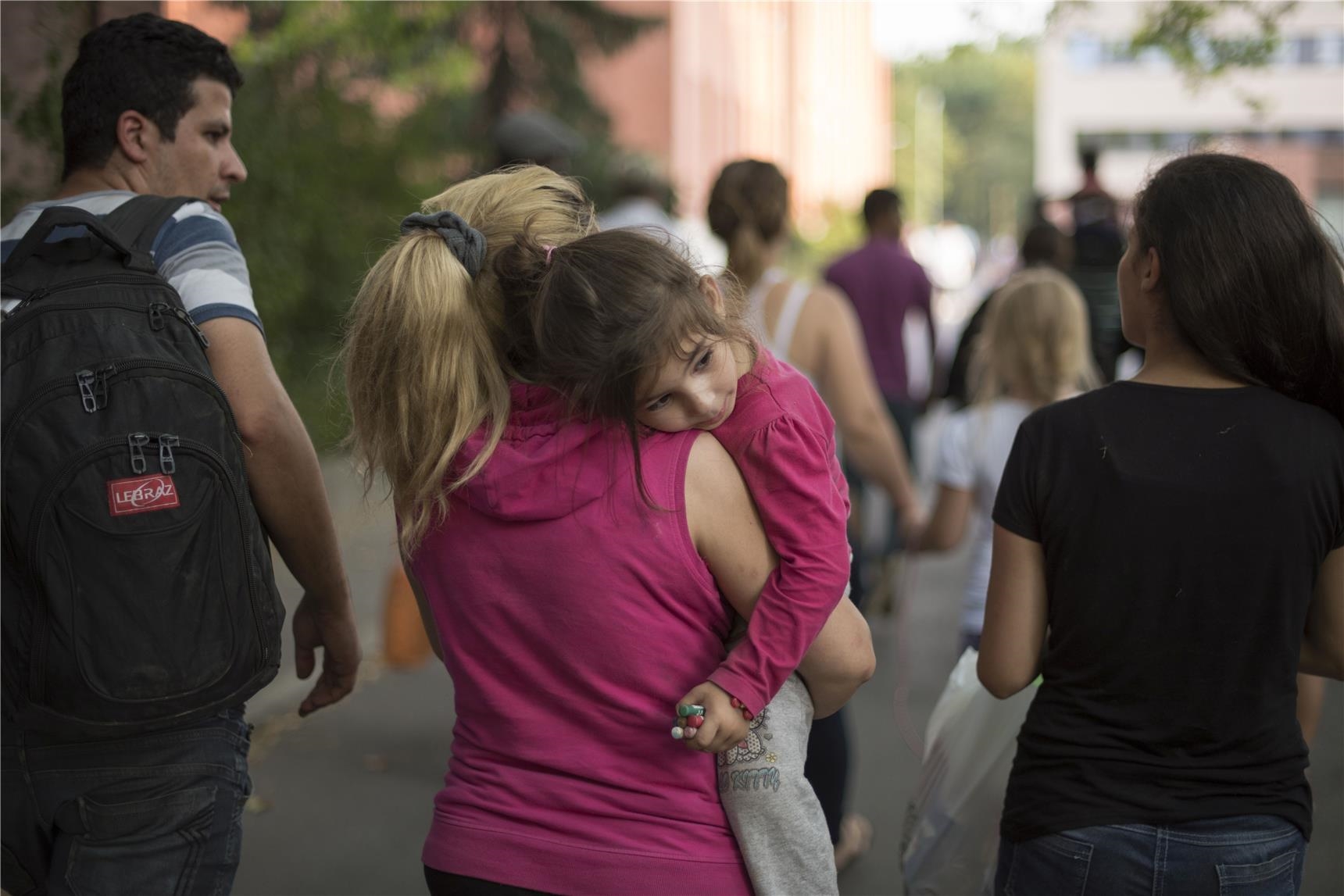 Eine Frau trägt ihr Mädchen auf dem Arm vor dem LaGeSo in Berlin