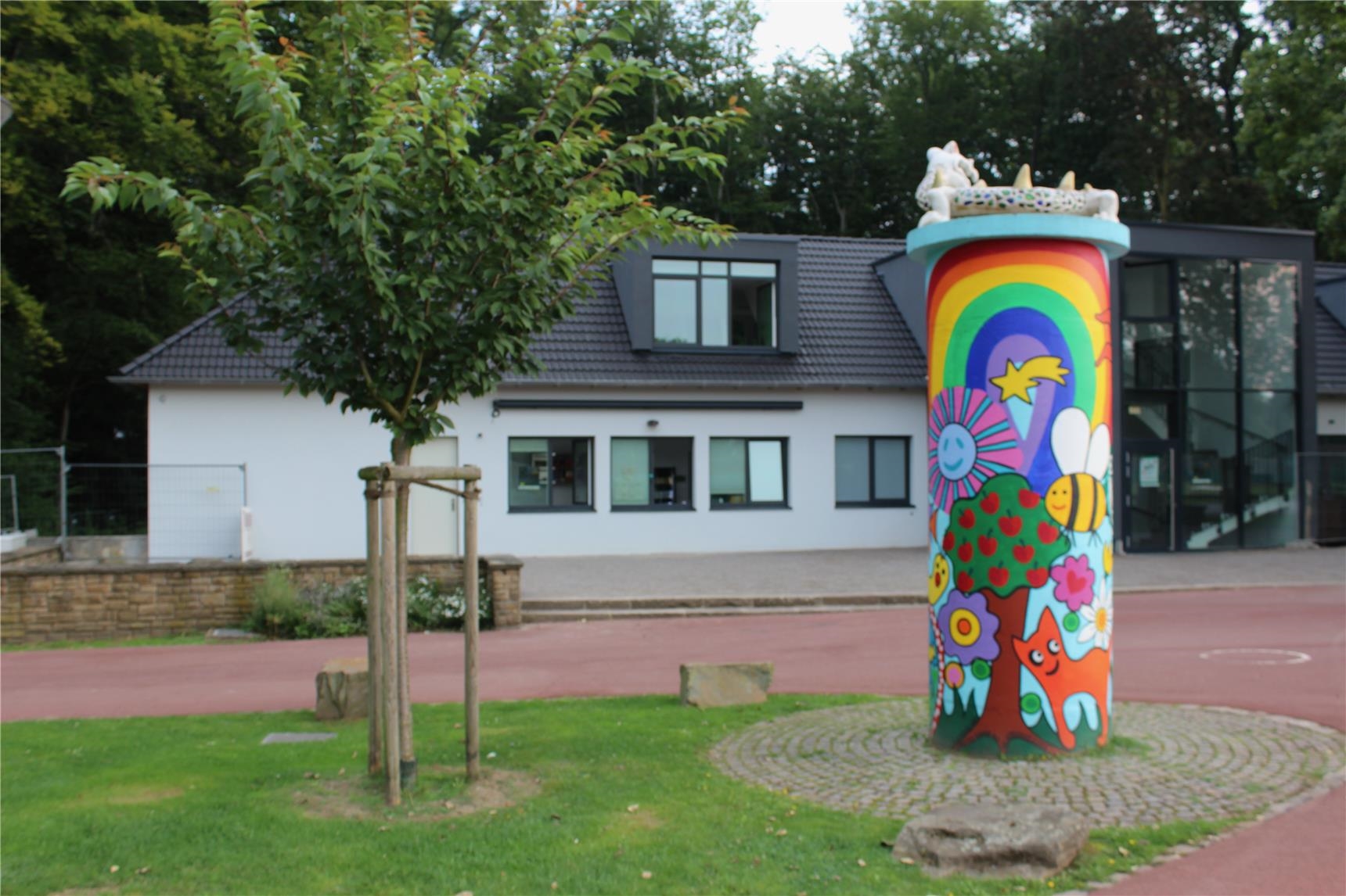 Vor dem Hoeschpark-Büdchen steht eine bunte Litfasssäule. 