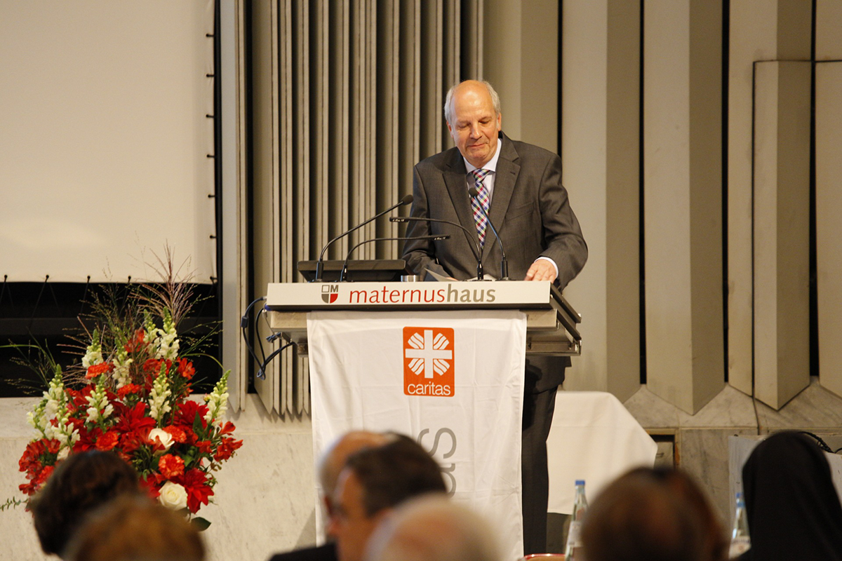 Heinz-Josef Kessmann steht beim Fachforum 'Von der Kunst, ein christliches Unternehmen zu führen' vor einem Pult und hält eine Begrüßungsrede (Martin Karski)