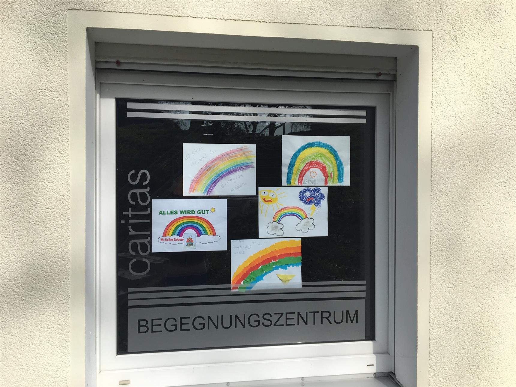Bilder mit gemalten Regenbogen in einem Fenster 